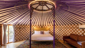 Une pièce comprenant un lit, un canapé et un tapis à motifs.