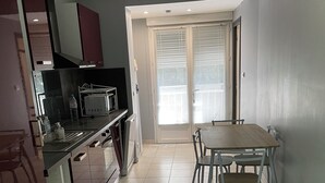 A modern kitchen with a dining area, featuring a microwave, sink, and cabinets. - Getaway to Carmaux (Carmaux)