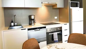 A modern kitchen with a built-in coffee maker, a microwave, a dishwasher, and an oven. - Modern and Elegant 1BD Apartment in the CBD (Melbourne)