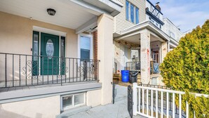 A residential building with a green door, a balcony with a white railing, and a tree in front. - 6 Mi to Eagles Games: Stylish Philly Townhome! (Philadelphia)