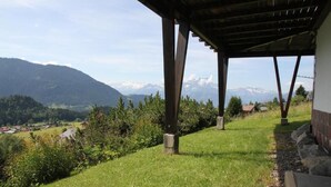 Un espace extérieur abrité offrant une vue sur un paysage montagneux.