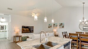 A modern kitchen with a marble countertop, stainless steel sink, and pendant lighting. - Walk to Whitecap Beach: Corpus Christi Retreat (Corpus Christi)