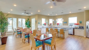 A spacious kitchen with a central island, dining area with wicker chairs, and a ceiling fan. - Walk to Whitecap Beach: Corpus Christi Retreat (Corpus Christi)