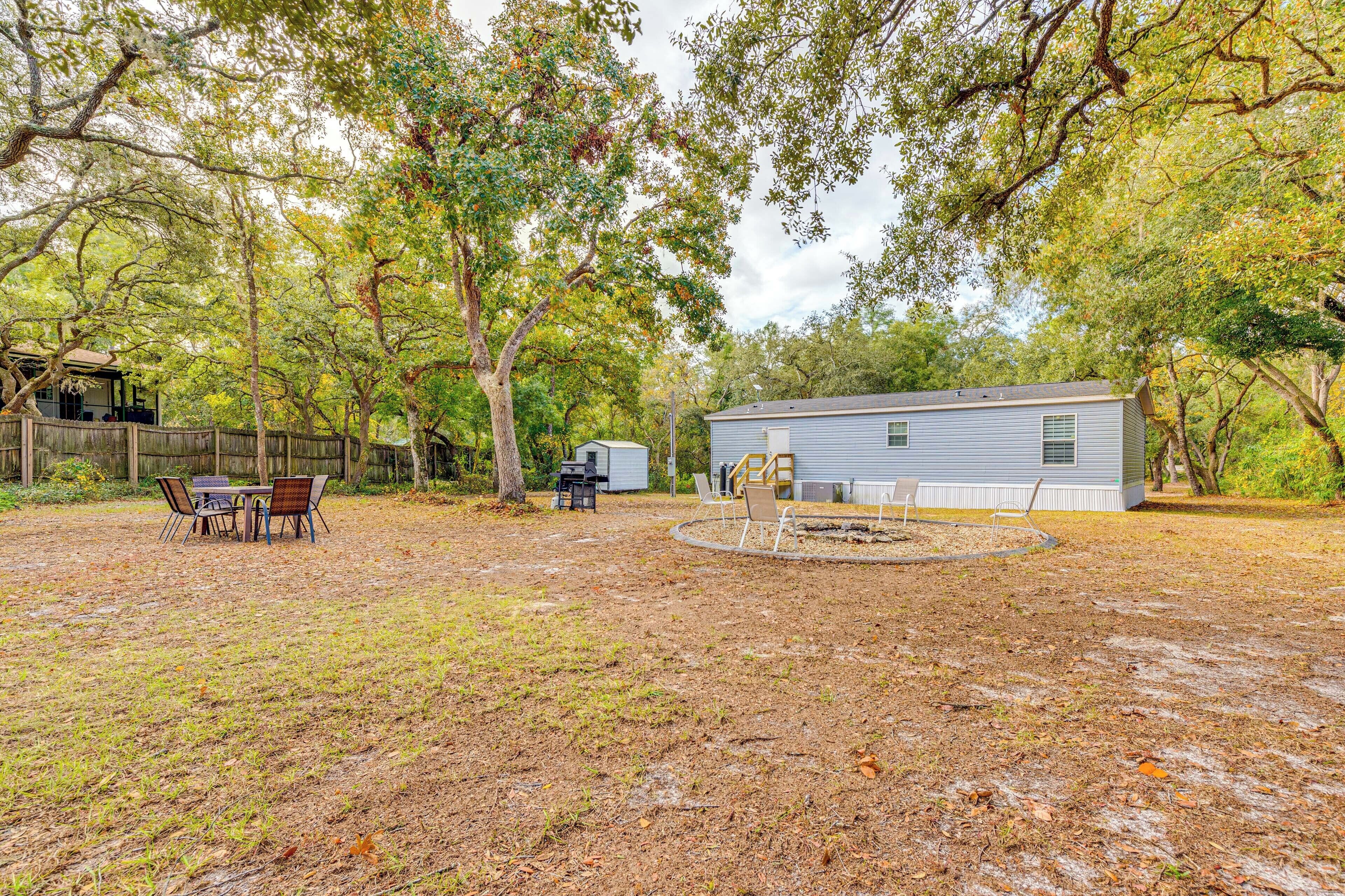 A backyard with a covered patio, a small shed, and a house.