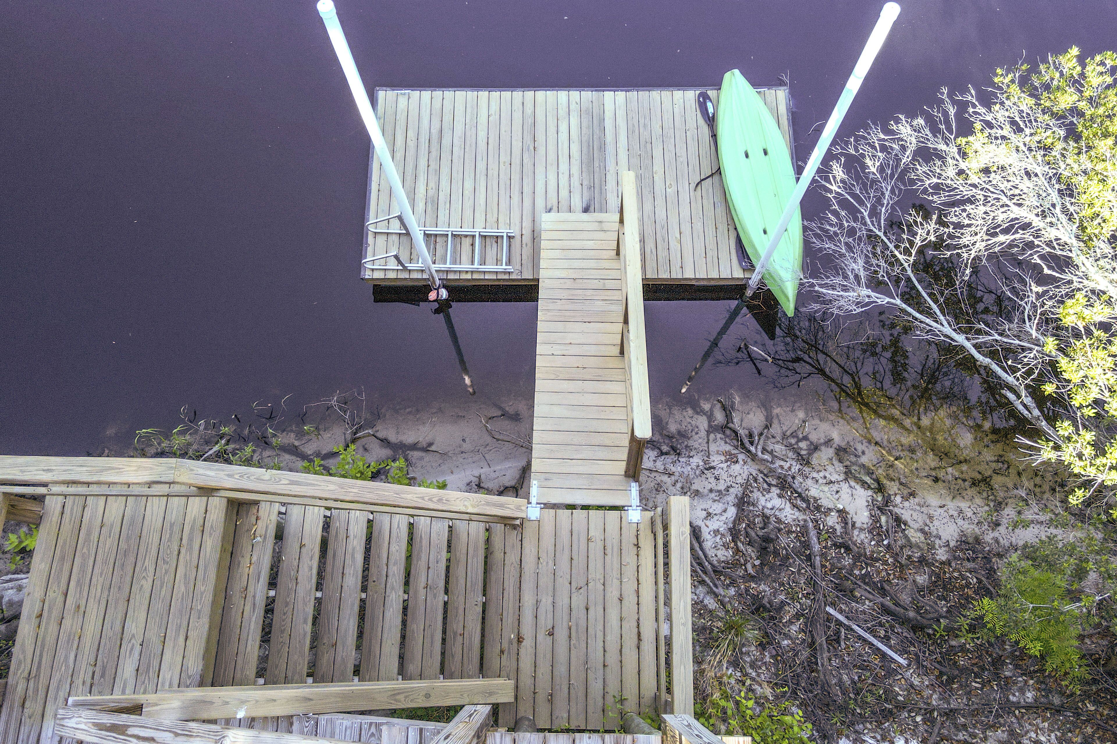 A wooden deck with a ladder leading to a platform.