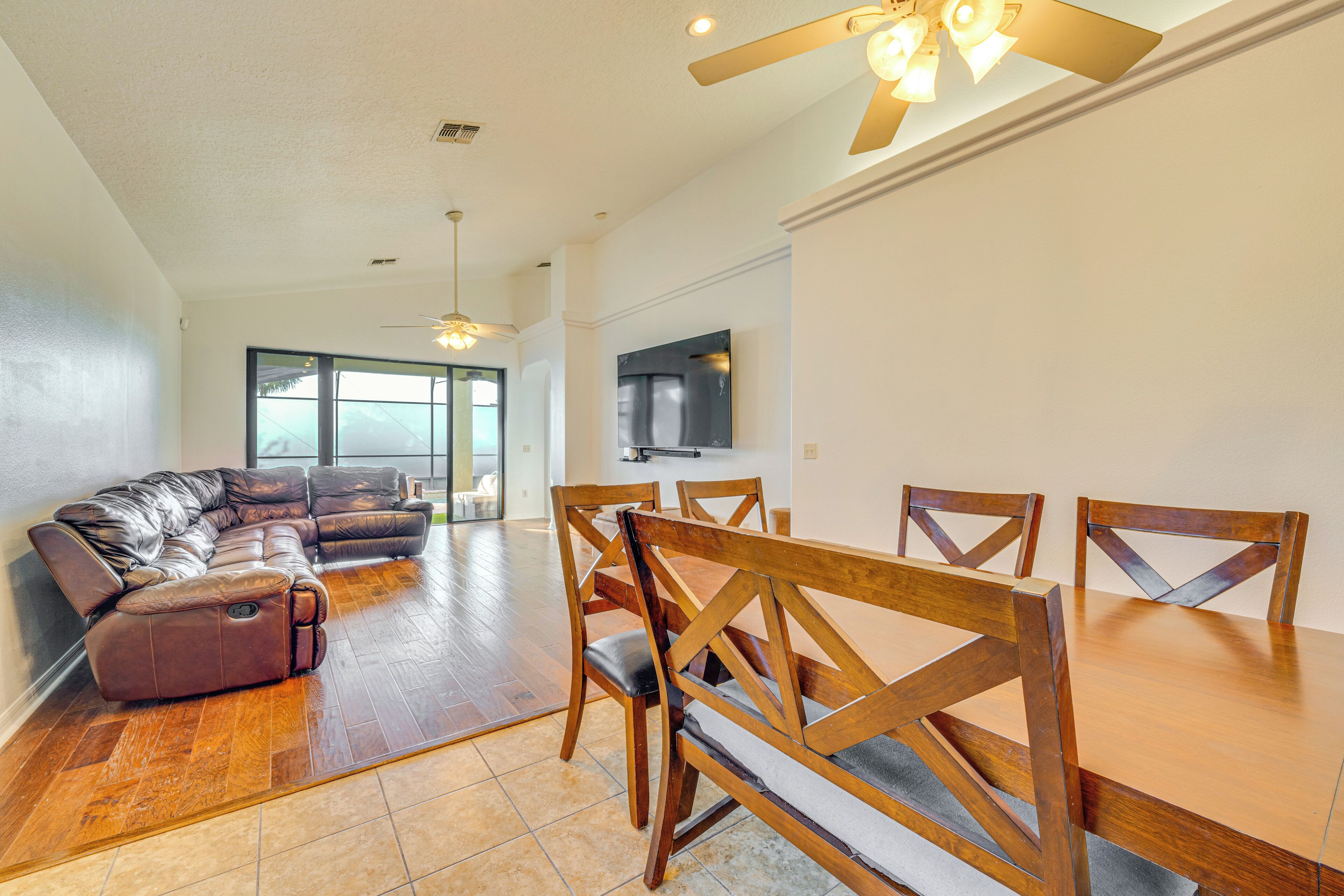 A spacious living area with a sectional sofa, wooden dining table, and chairs.