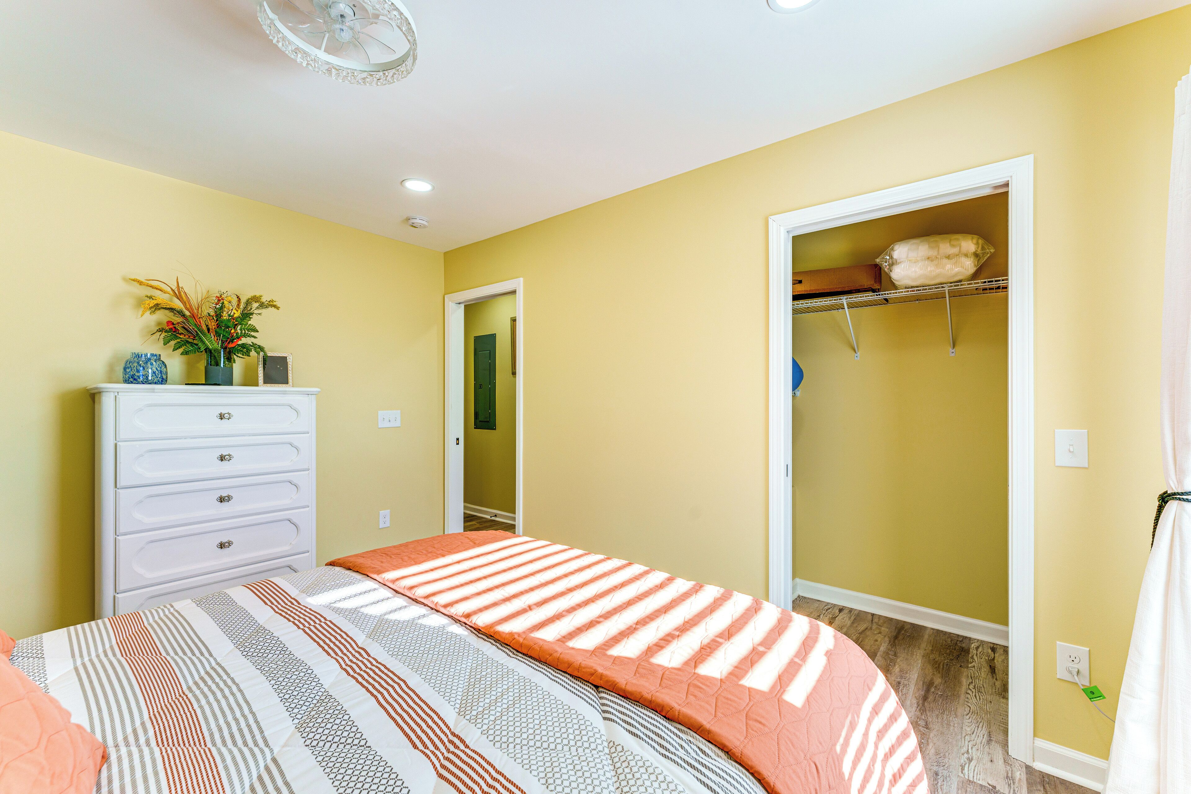 A bedroom with a bed, dresser, and closet.