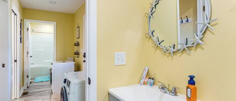 A bathroom with a sink, mirror, and starfish decoration.