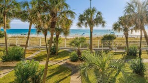 Ein Strand mit Palmen, einem Pfad und Blick auf den Ozean.