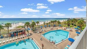 Ein Resort mit Poolbereich, Strand und Palmen.