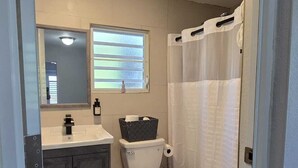 Ein Badezimmer mit Toilette, Waschbecken und Duschvorhang.