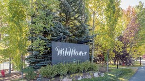 Un letrero con la palabra 'Wildflower' rodeado de árboles y una zona con césped.