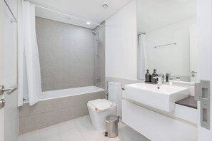 Un baño moderno con bañera, inodoro, lavabo y ducha.