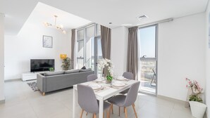 Un salon moderne comprenant un coin repas, un canapé, un téléviseur et un balcon avec vue.