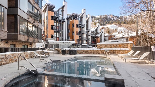 Ein modernes Gebäude mit Poolbereich, inklusive Liegestühlen und einem Whirlpool.