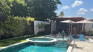 Piscina rectangular con borde de azulejos, rodeada de una terraza de piedra.
