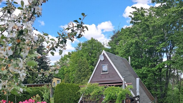 Una casa con techo inclinado, antena parabólica y una ventana pequeña.