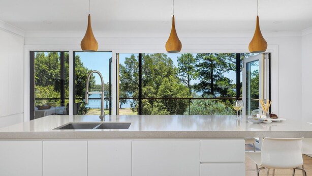 A modern kitchen with a large window, a sink, and pendant lights. - Rivers Edge Oasis -Karuah, Infinity Pool and Private Cinema room (Karuah)