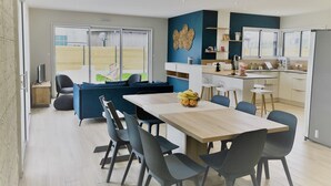 Une cuisine moderne avec un coin repas, un canapé et une vue sur l’extérieur.
