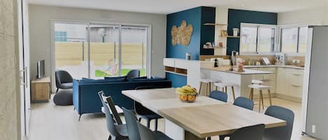 Una cocina moderna con comedor, sofá y vistas al exterior.