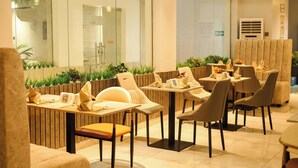 A modern restaurant with a mix of indoor and outdoor seating, featuring a variety of table and chair styles. - The Bridge Hotel (Ibadan)