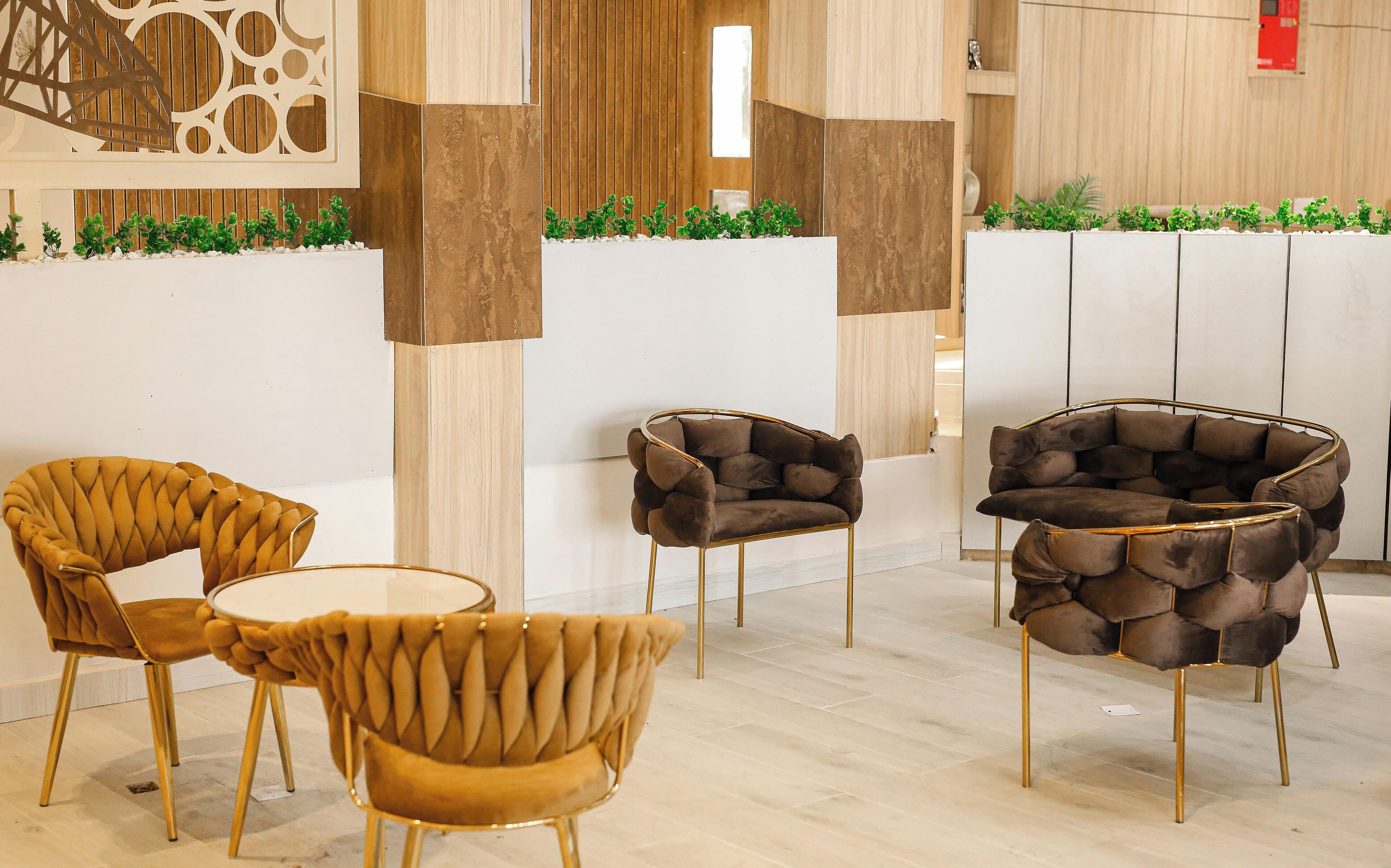 A modern interior with a seating area featuring two round tables and three chairs with unique designs.