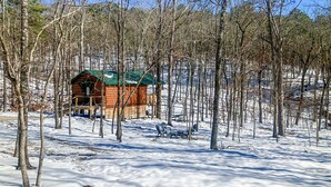 A wooden cabin surrounded by trees in a snowy landscape. - Cozy Treehouse For 2 | Outdoor Spa Tub + Fire Pit (Hot Springs)