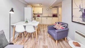 A compact living space with a dining area, kitchenette, and a cozy seating area with a flag pillow. - Host & Stay | Roper Road (Canterbury)