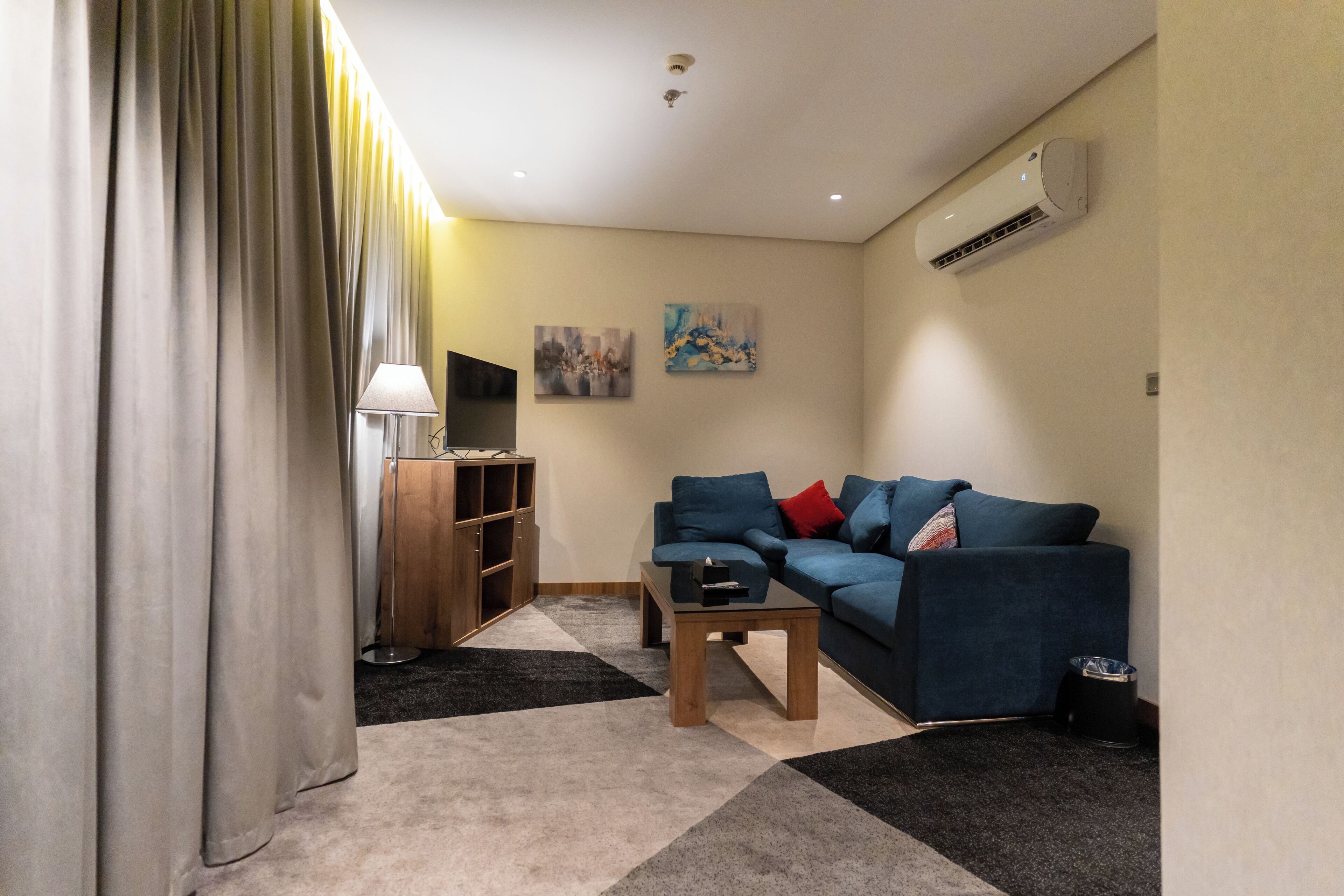 A living room with a sofa, a coffee table, a TV, and a bookshelf.