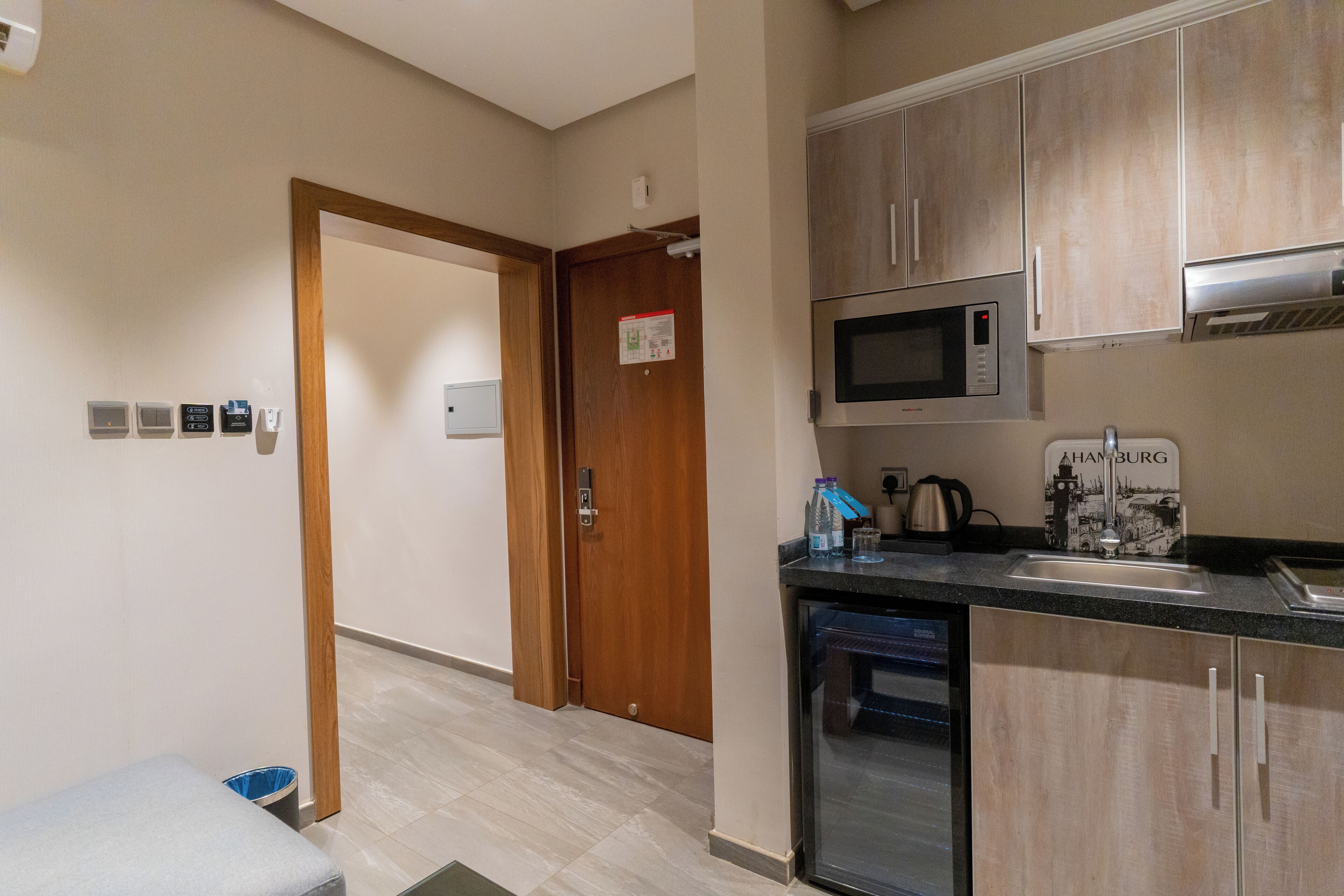 A kitchen with wooden cabinets, a microwave, a sink, and a dishwasher.