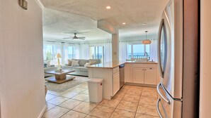 A modern kitchen with white cabinetry, a stainless steel refrigerator, and a large window offering a view of the outdoors. - ⭐Unique, Stunning Views-Fantastic Location-Land's End 9-301⭐ (Treasure Island)