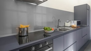 A modern kitchen with a black countertop, stainless steel appliances, and a pot of spaghetti. - Il Villino Del Collezionista With Pool In Pistoia (Pistoia)