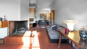 A modern living room with a fireplace, a sofa, a coffee table, and a lamp. - Il Villino Del Collezionista With Pool In Pistoia (Pistoia)