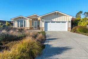 Stunning two-story home with a central entrance and beautifully manicured grounds.