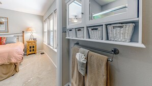 Un dormitorio con cama, mesita de noche, lámpara y ventana con persianas.