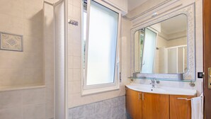 A bathroom with a shower, a sink, and a large mirror. - La Pineta sul Mare by Wonderful Italy (Sanremo)
