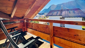 Eine Holzterrasse mit Blick auf Berge und einen klaren Himmel.