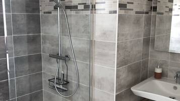 Regadera, secadora de cabello, toallas, papel de baño