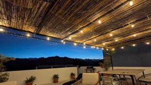 An outdoor patio area with string lights, seating, and potted plants. - Villa La Roca - A fusion of modern and typical Andalucian architecture (Montecorto)