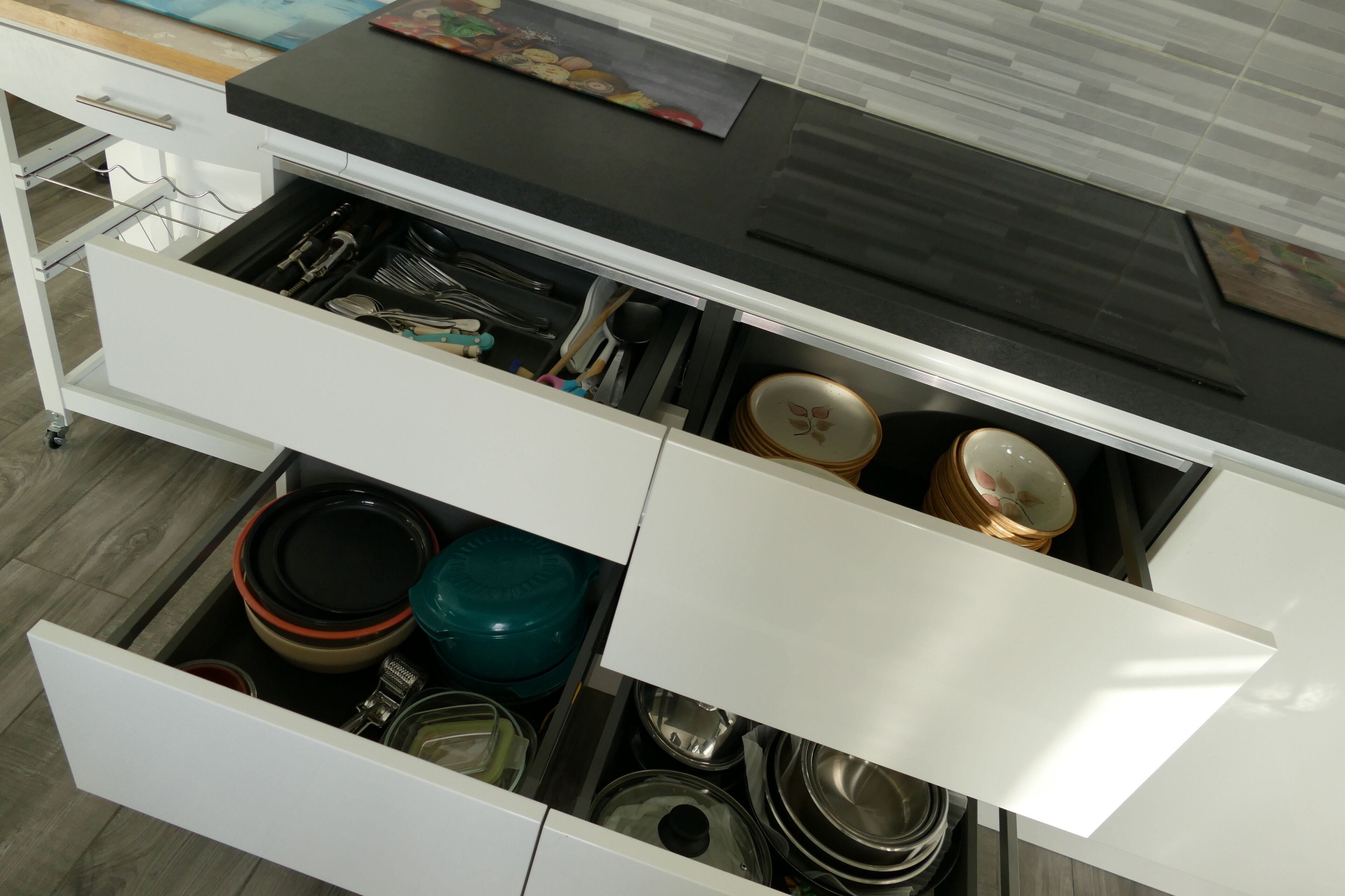 A kitchen drawer with various kitchen utensils and cookware.