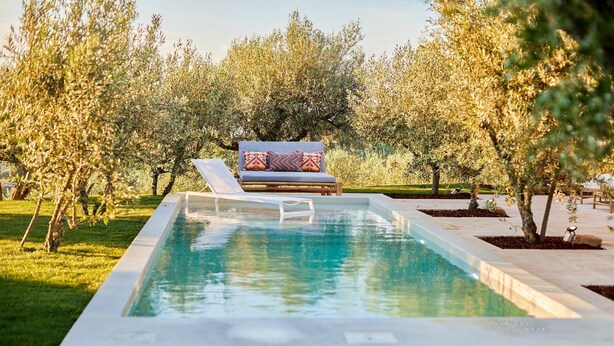 A rectangular pool with a lounge chair and cushions in the background. - Olive Tree House - Two Bedroom Villa, Sleeps 4 (Fontelo)