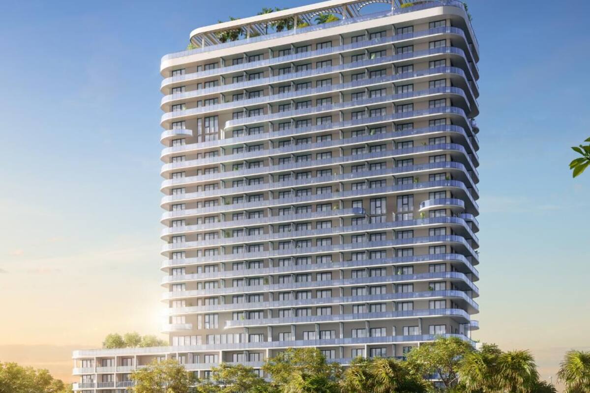 A modern high-rise hotel with multiple balconies and a rooftop garden.