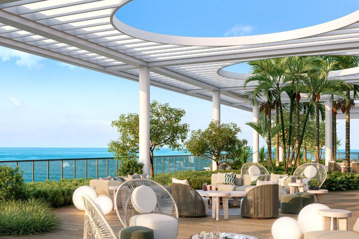 A modern outdoor lounge area with seating and a view of the ocean.