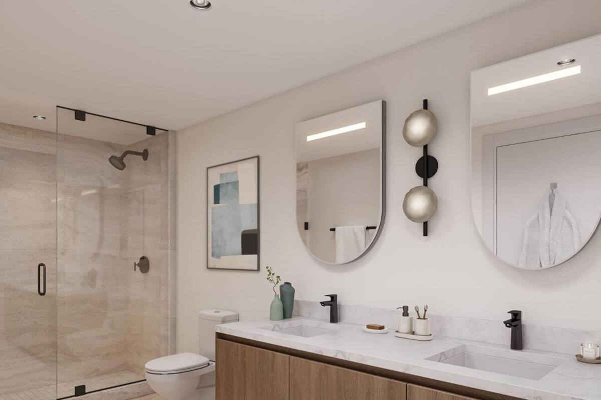 A modern bathroom with a glass-enclosed shower, a white toilet, a vanity with a marble countertop, and two wall-mounted mirrors.