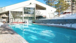 A modern building with large windows and a swimming pool.