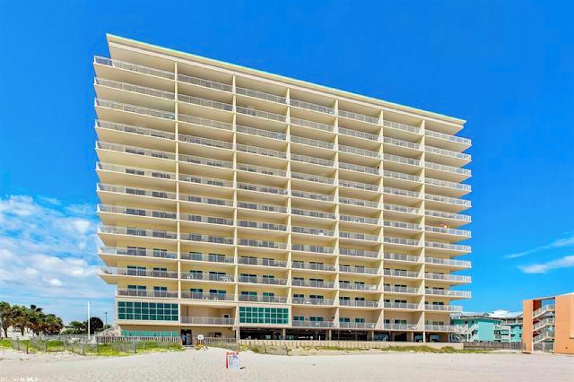 A multi-story hotel with a uniform facade, balconies on each floor, and a flat roof.