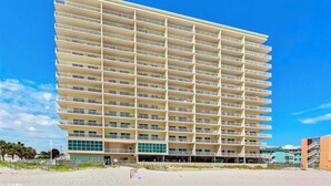 A multi-story hotel with a uniform facade, balconies on each floor, and a flat roof.