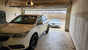 A garage with two cars parked inside.