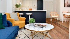 Ein modernes Wohnzimmer mit einer Couch, einem Couchtisch und einem Essbereich mit Stühlen.