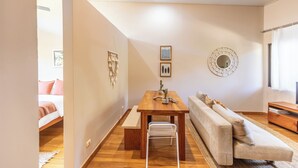 Una sala de estar moderna con una mesa de comedor de madera, un sofá y una pequeña mesa de centro.